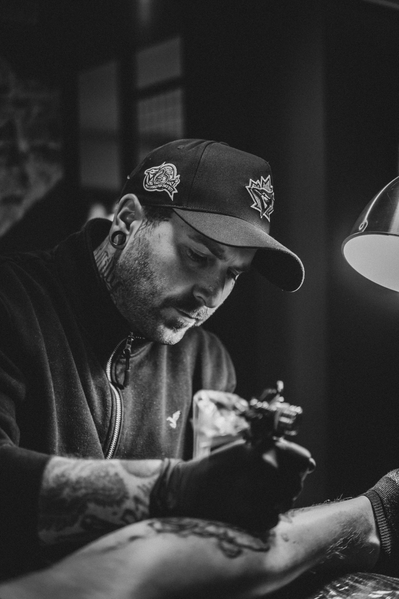 Tatoeëerder geconcentreerd aan het werk in zijn studio