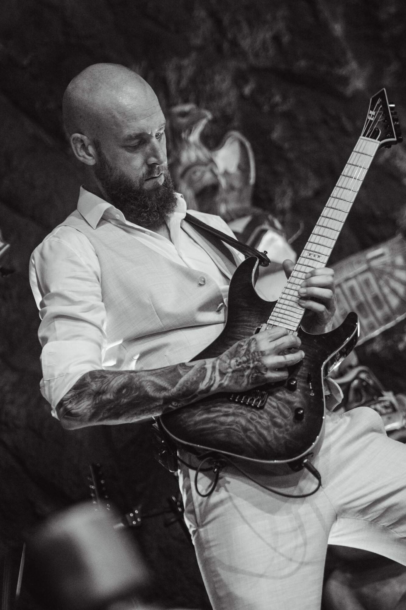 Groom playing guitar during the wedding performance in black and white